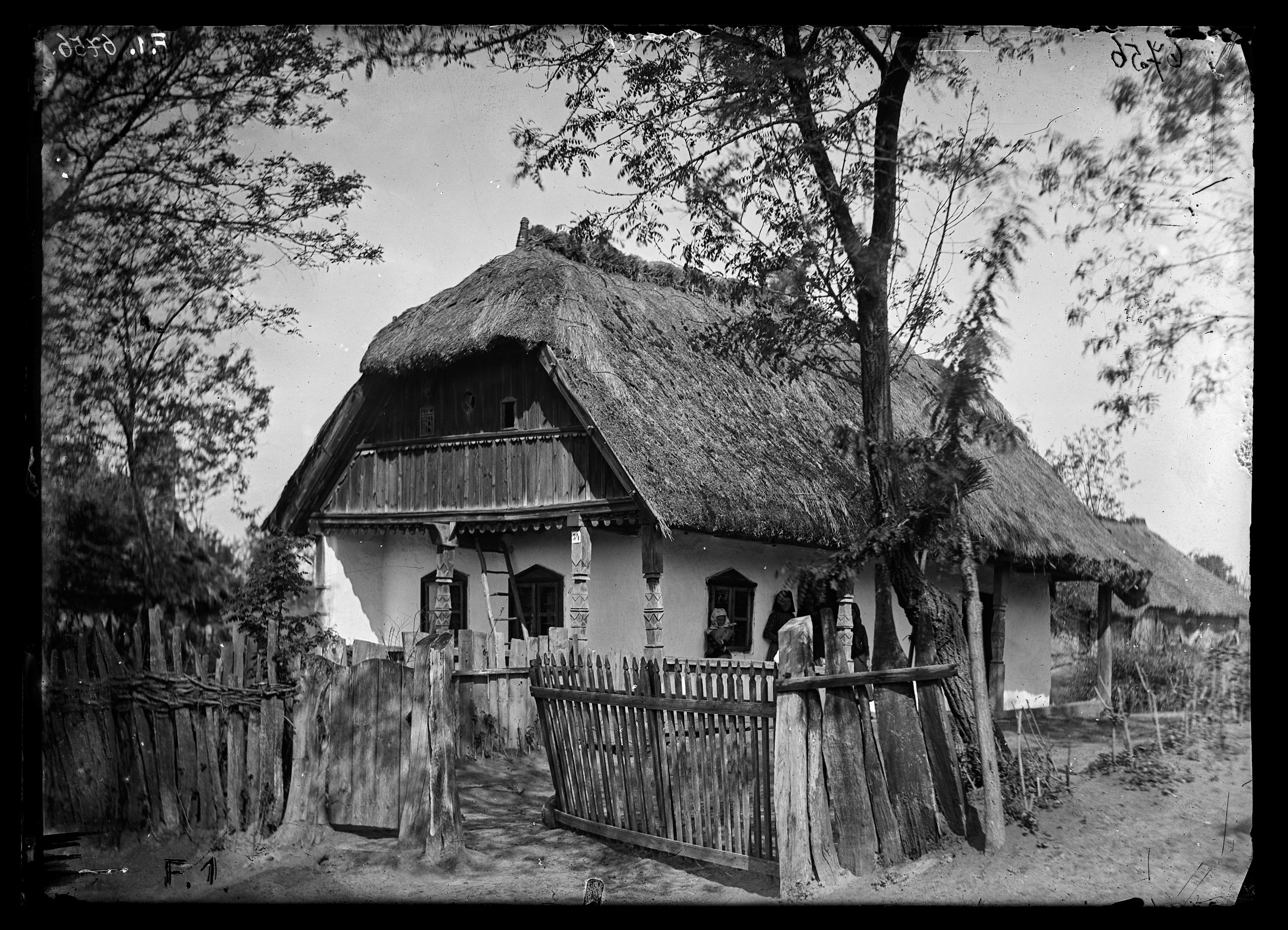 Elő- és oldaltornácos magyar ház díszesen faragott tornácoszlopokkal